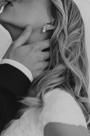 Black and white close-up photo showing soft blonde hair cascading over shoulder and neck with an elegant ring visible.