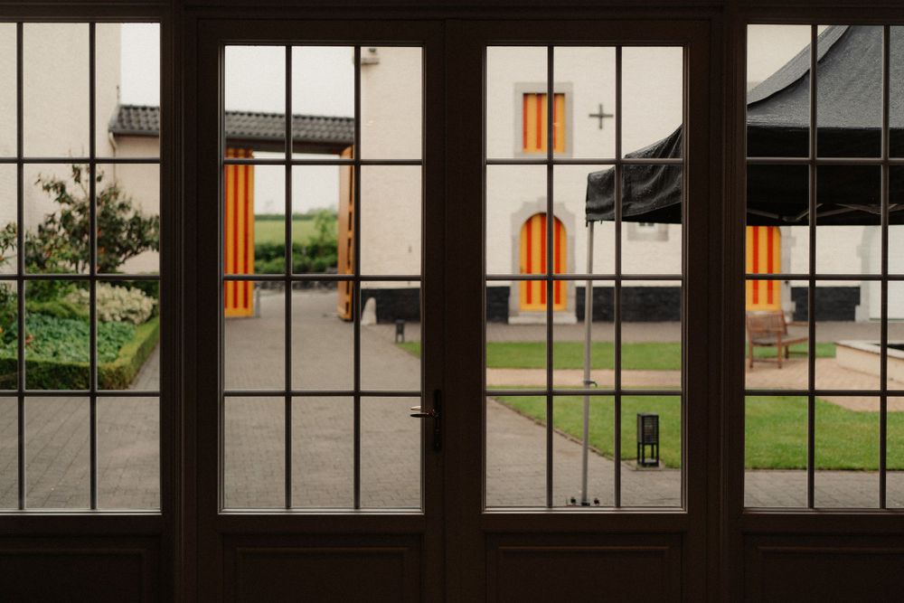 View through divided glass doors showing orange architectural elements in the distance.