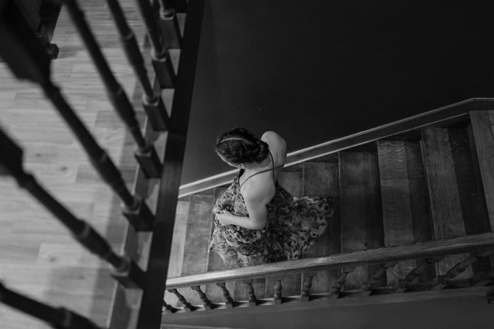 A decorative black and white photograph showing stairs and railing with dramatic shadows.