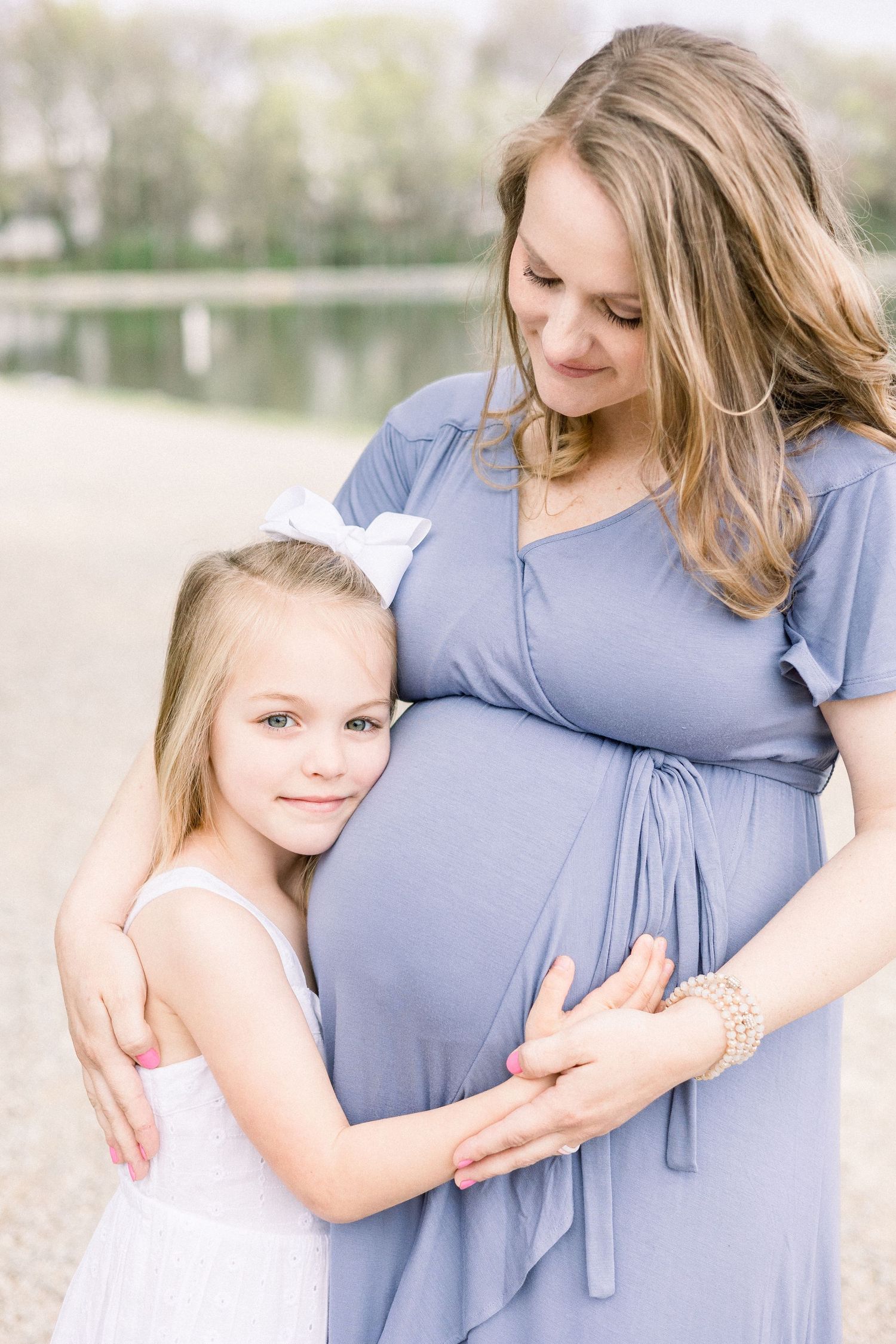Older sibling hugging mom’s belly during maternity session in Augusta, GA