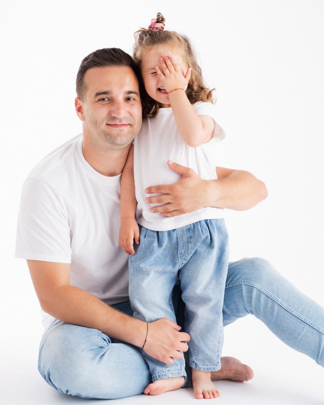 Fotografie de familie spontana cu o fetita si tatal ei,  expresie naturala de fericire autentica.