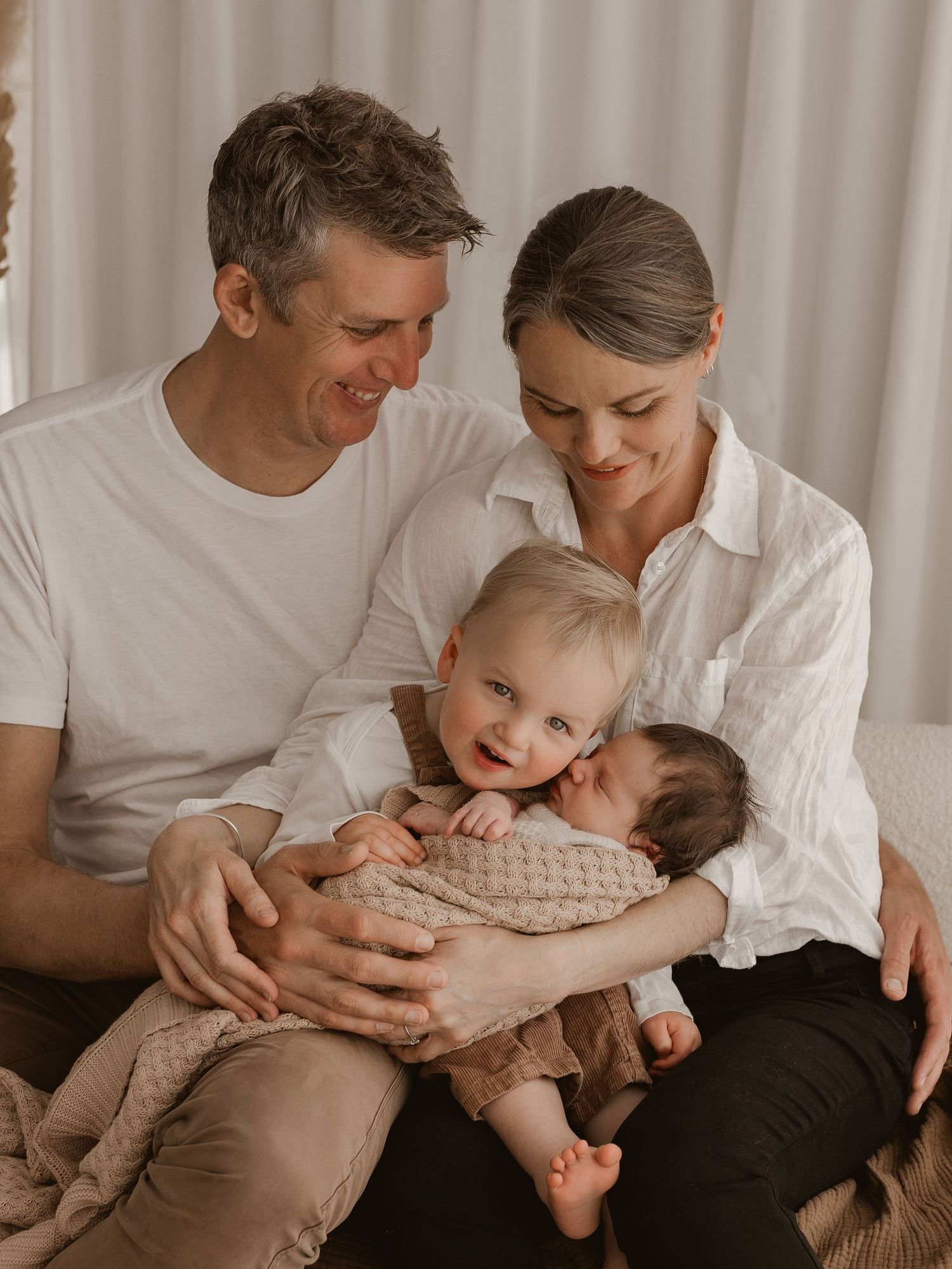 A heartwarming series of family photos showing tender moments between parents and their young child on a light backdrop.