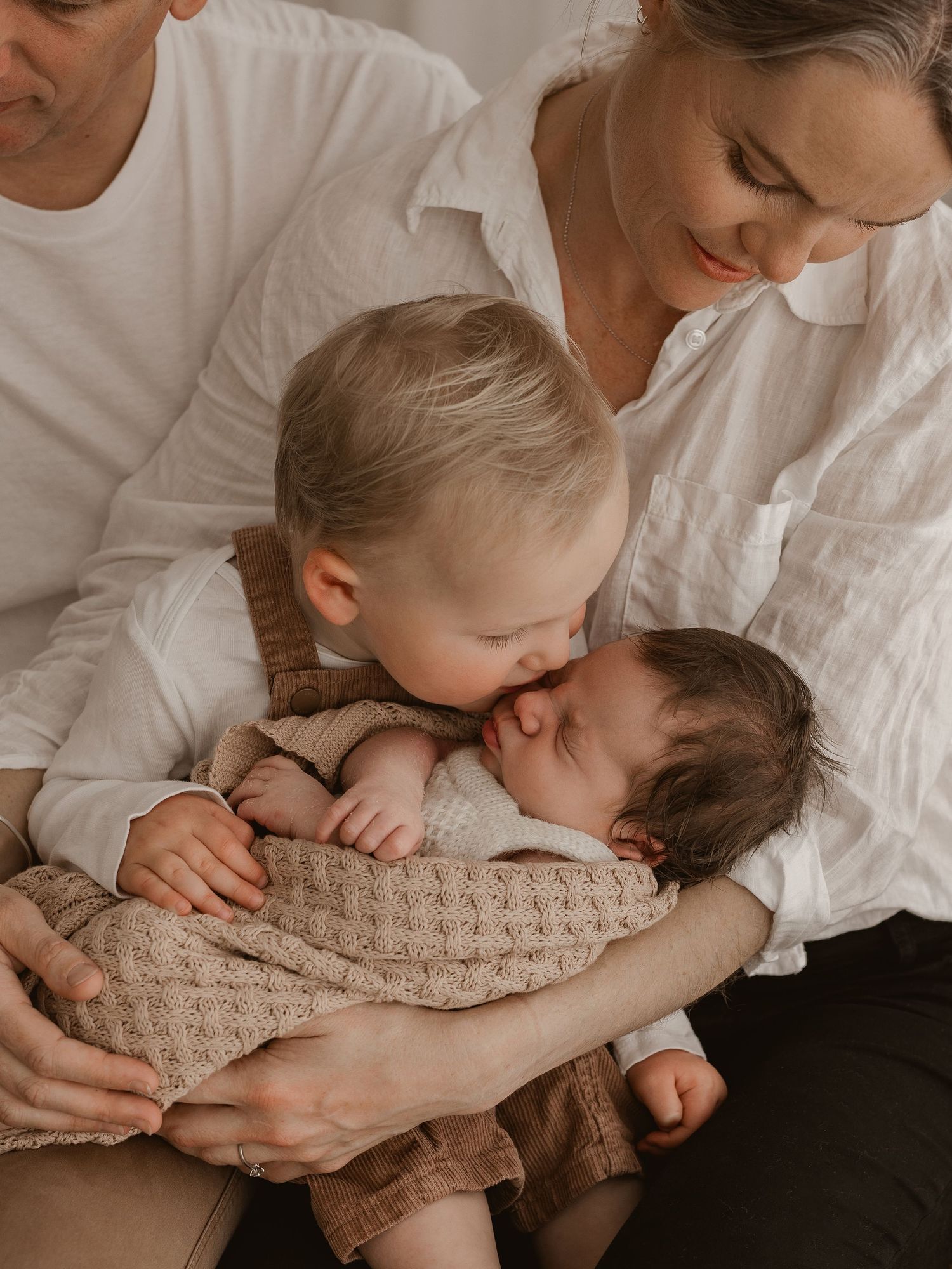 A tender moment captured in a series of four intimate black and white photos showing gentle embraces and kisses.