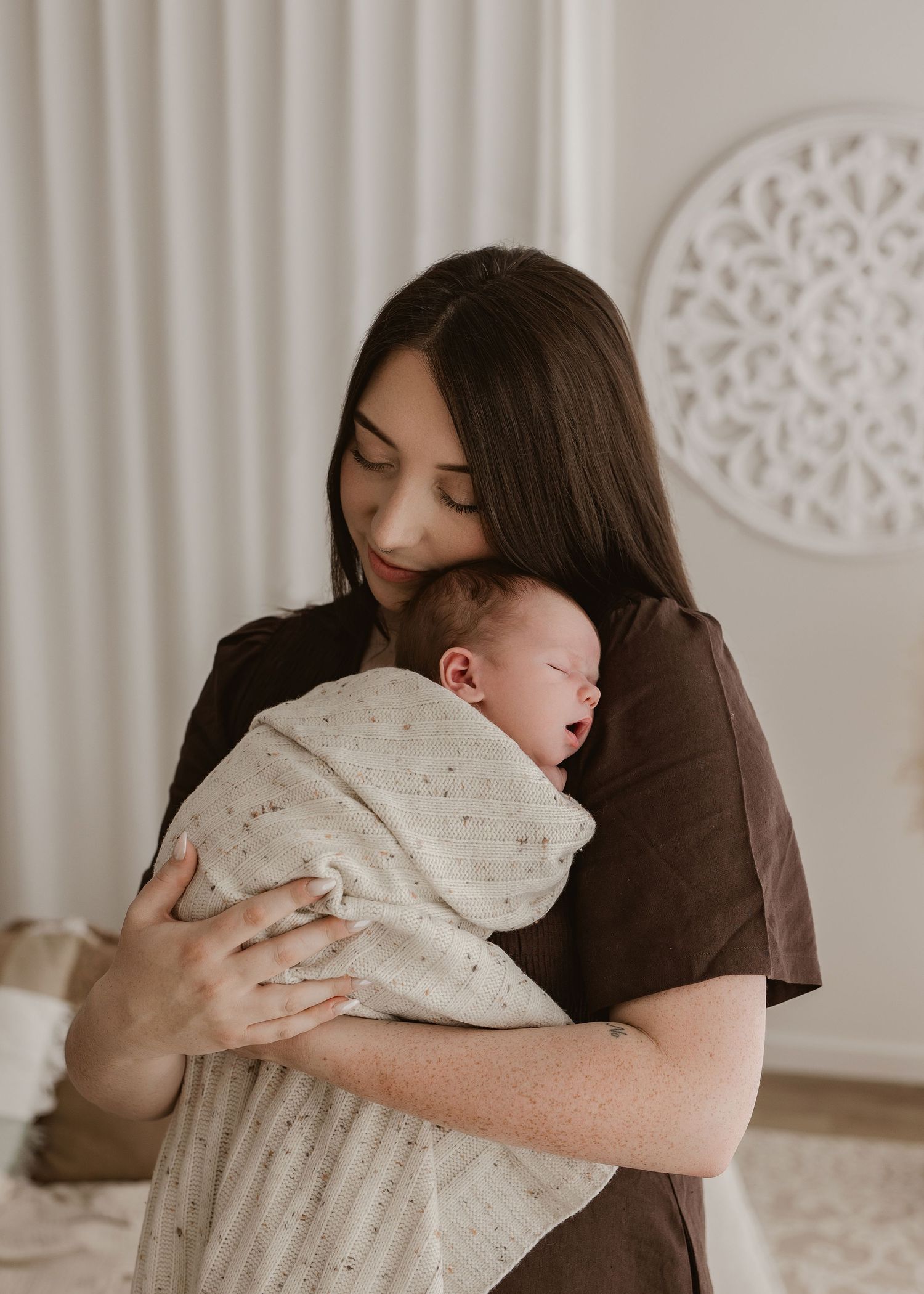 A series of tender embraces between parent and child in white decor against a light wall with ornate details.