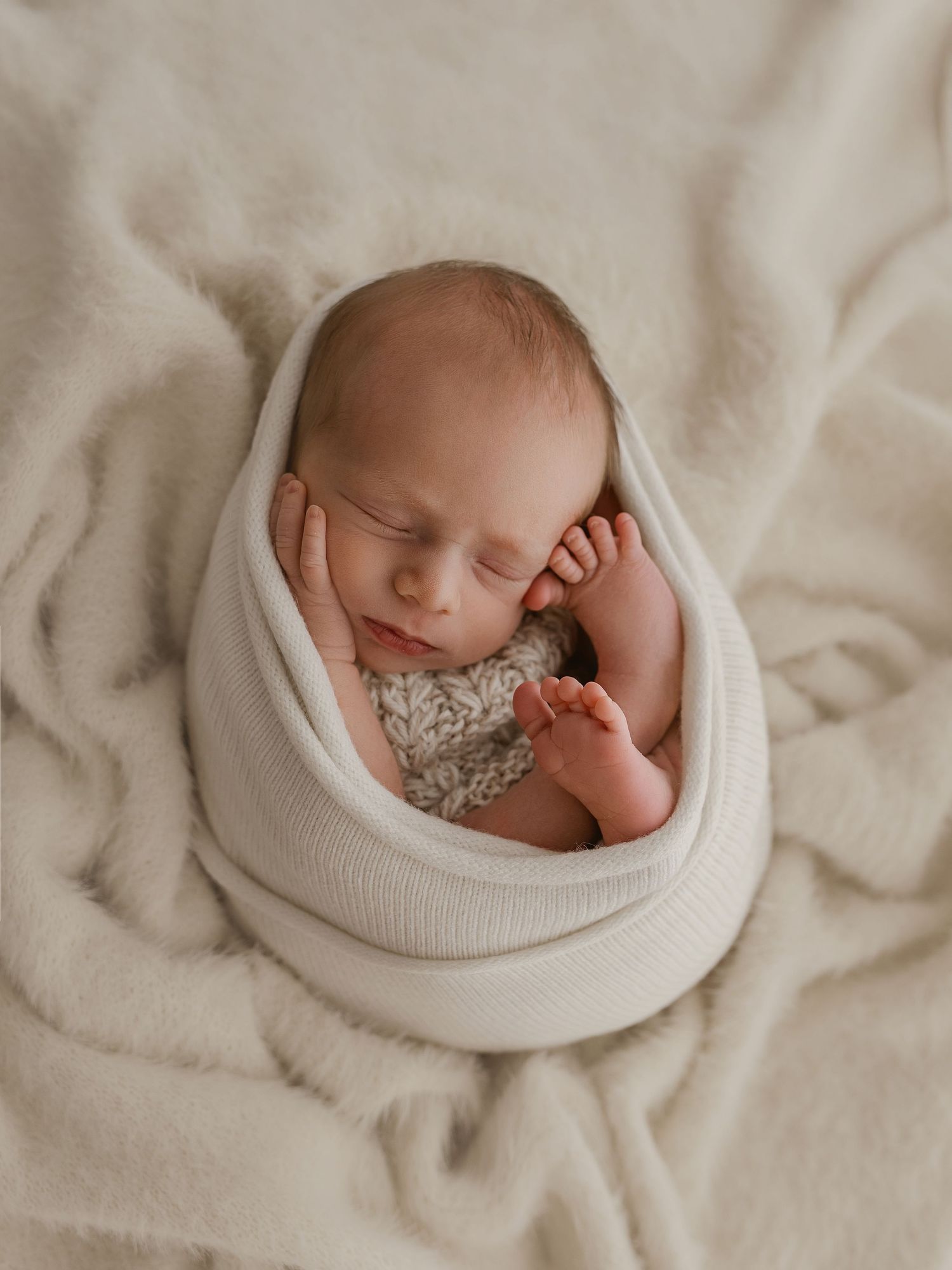 A series of soft, dreamy newborn photos showing a sleeping baby wrapped in white textiles against a neutral backdrop.