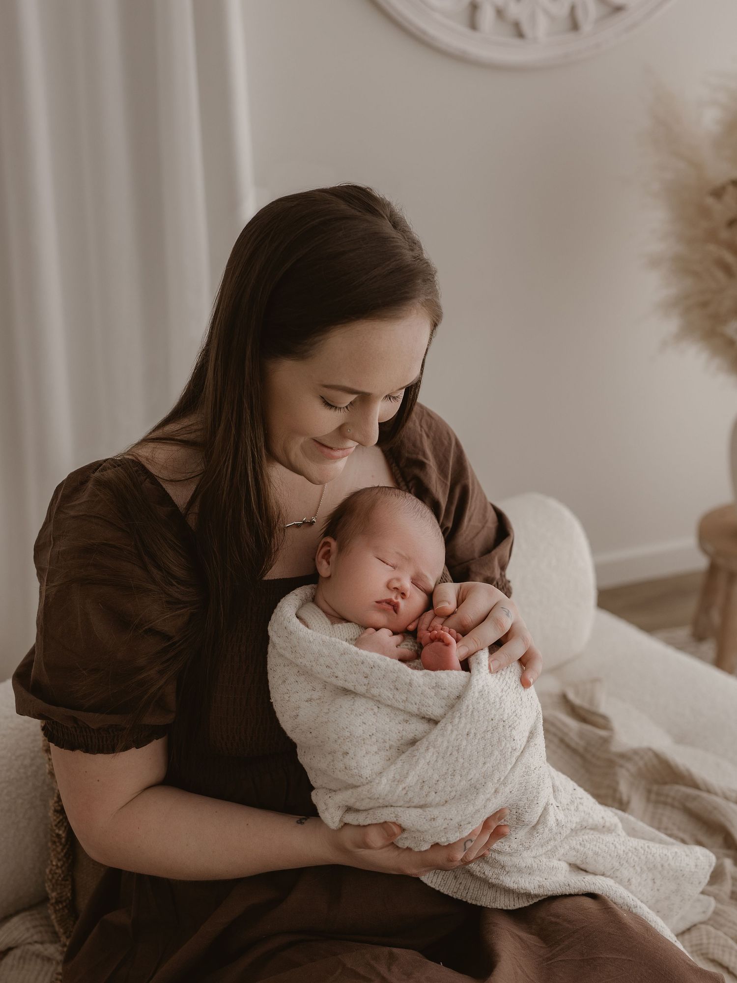 A tender moment captured in a series of intimate newborn photos with soft neutral tones and natural lighting.