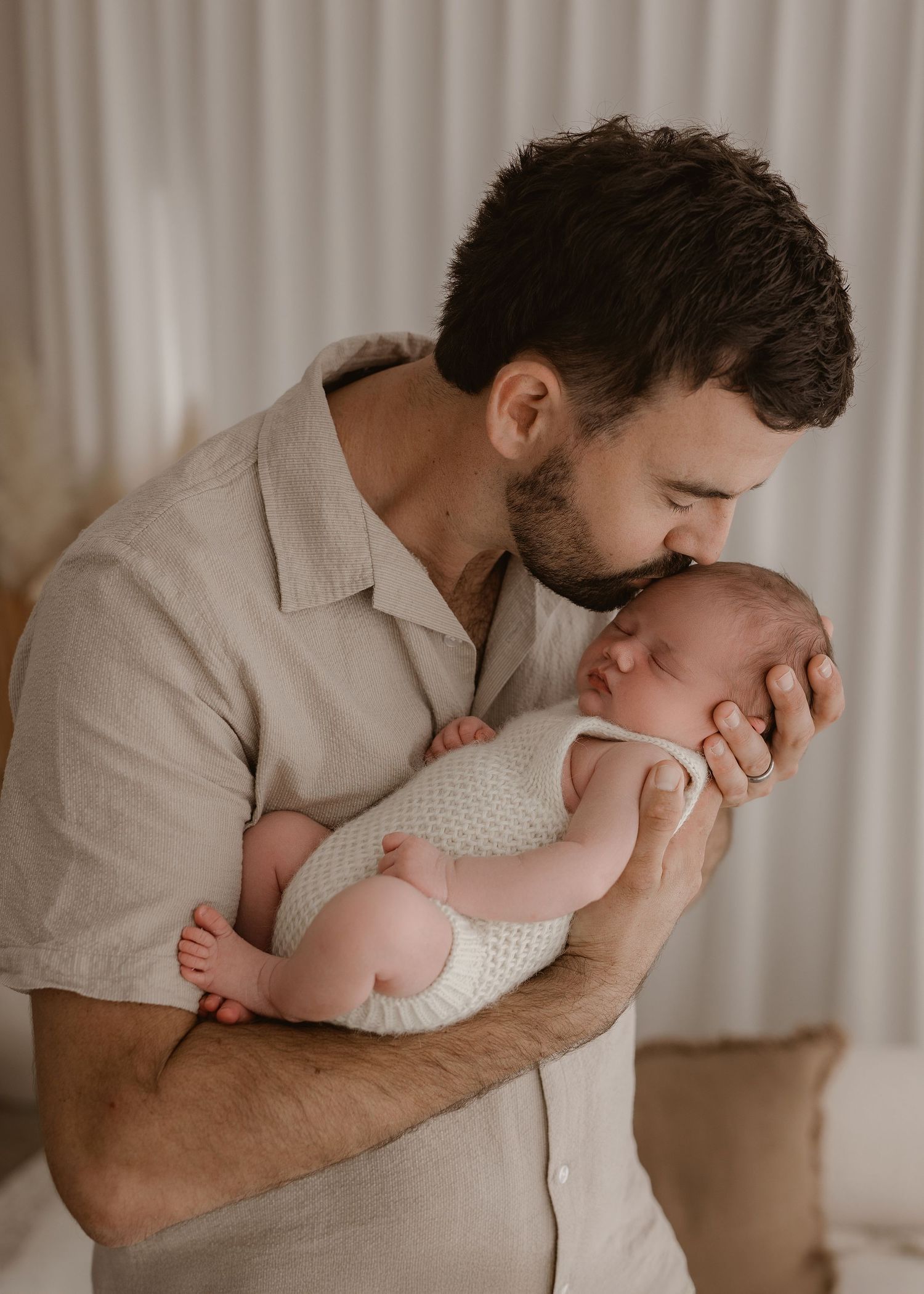 A tender moment between parent and infant shows gentle kisses and cuddles in a series of intimate photographs.