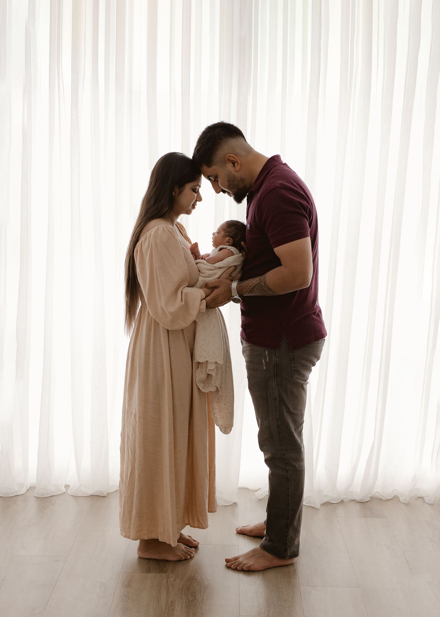 Three sequential photos show a couple in light and dark clothing interacting intimately against white curtains.