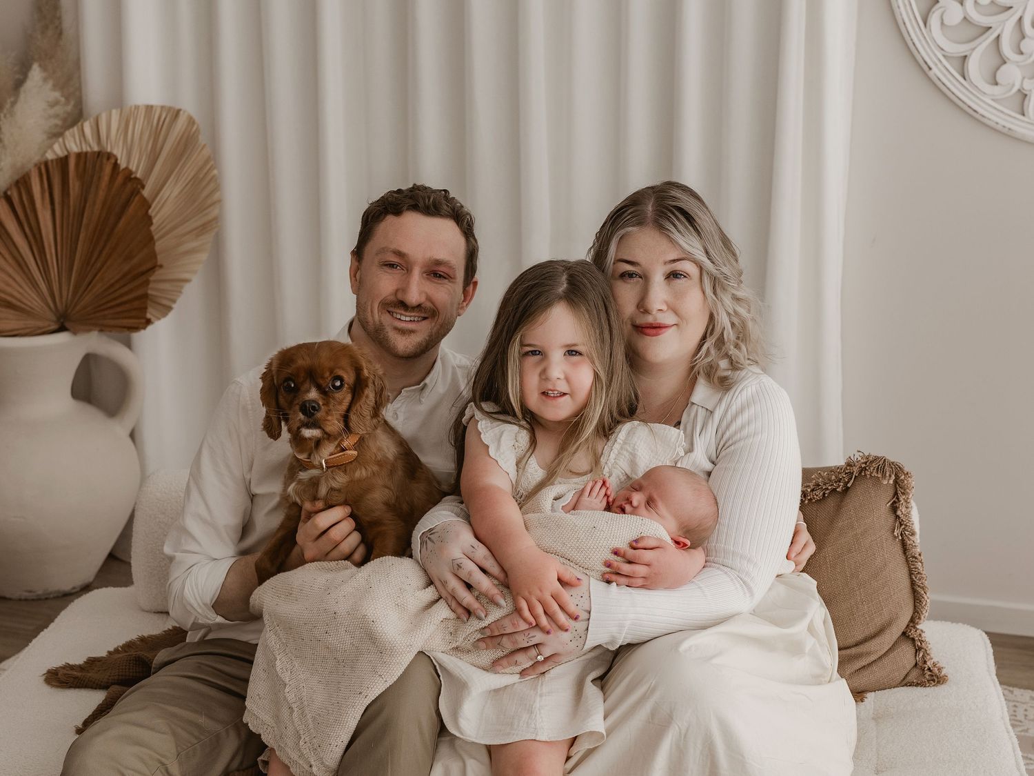 A series of candid family photos in warm neutral tones showing intimate moments at home with a small dog.