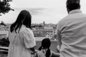 family posing together on a beautiful day in Upper Town, with historic architecture in the background.