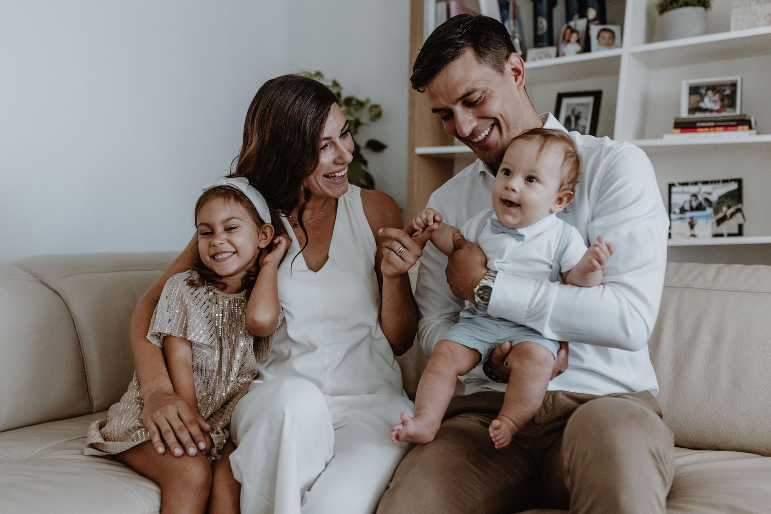 A family shares a joyful moment together on their living room couch.