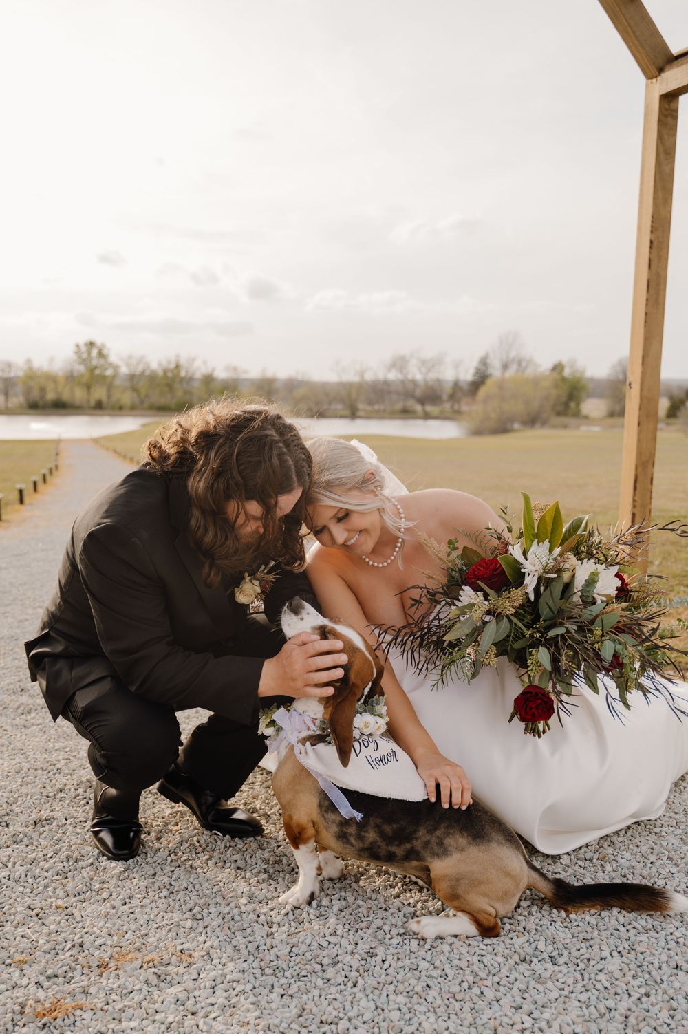 Couple sharing tender moment with their dog on gravel path. Oklahoma Wedding Photographer