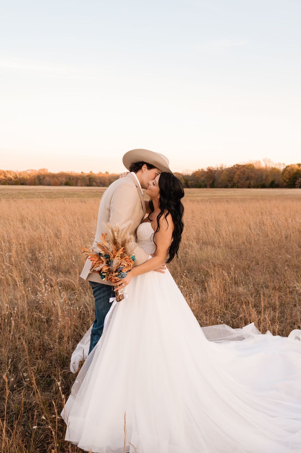 Bride in flowing white gown twirling in golden sunset field. Oklahoma Wedding Photographer