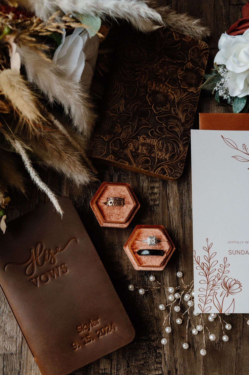 Wedding invitations and leather details with dried flowers and metallic accents on dark wood. Oklahoma Wedding Photographer