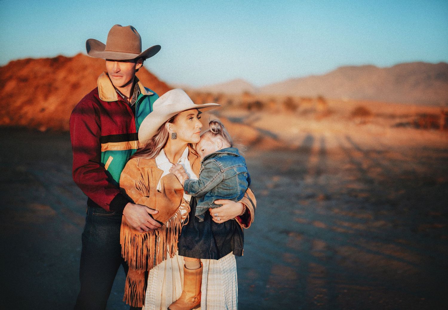 Family with small children poses together on nature trail at golden hour.