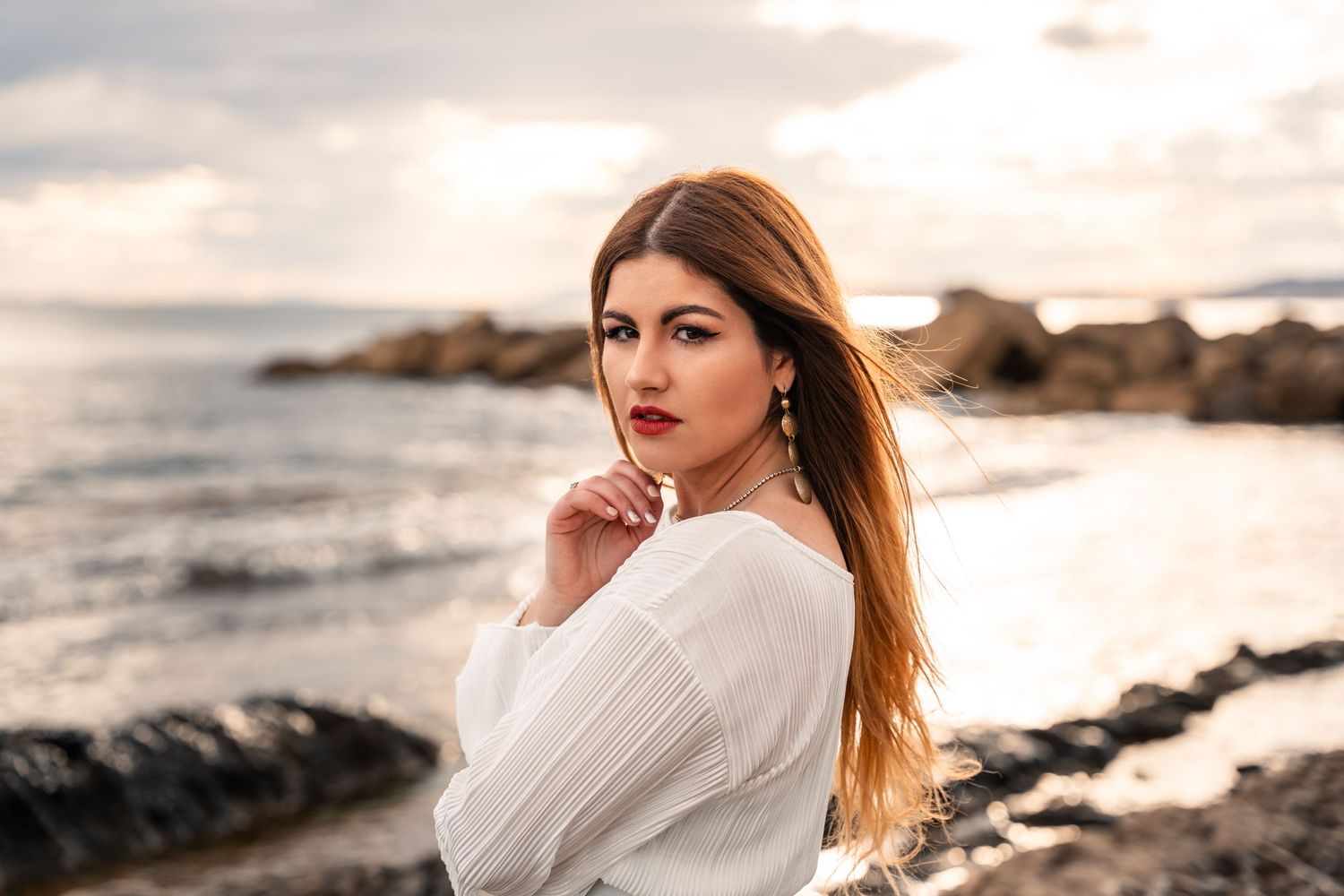 beautiful woman on the beach at sunset in Alicante with sultry look at camera