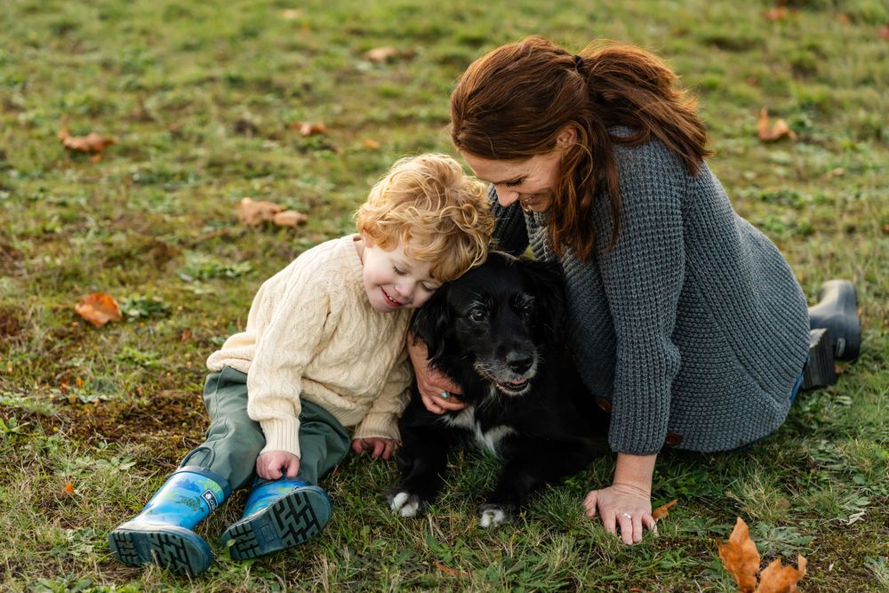 Family smiling and hugging their dog in North Bend.