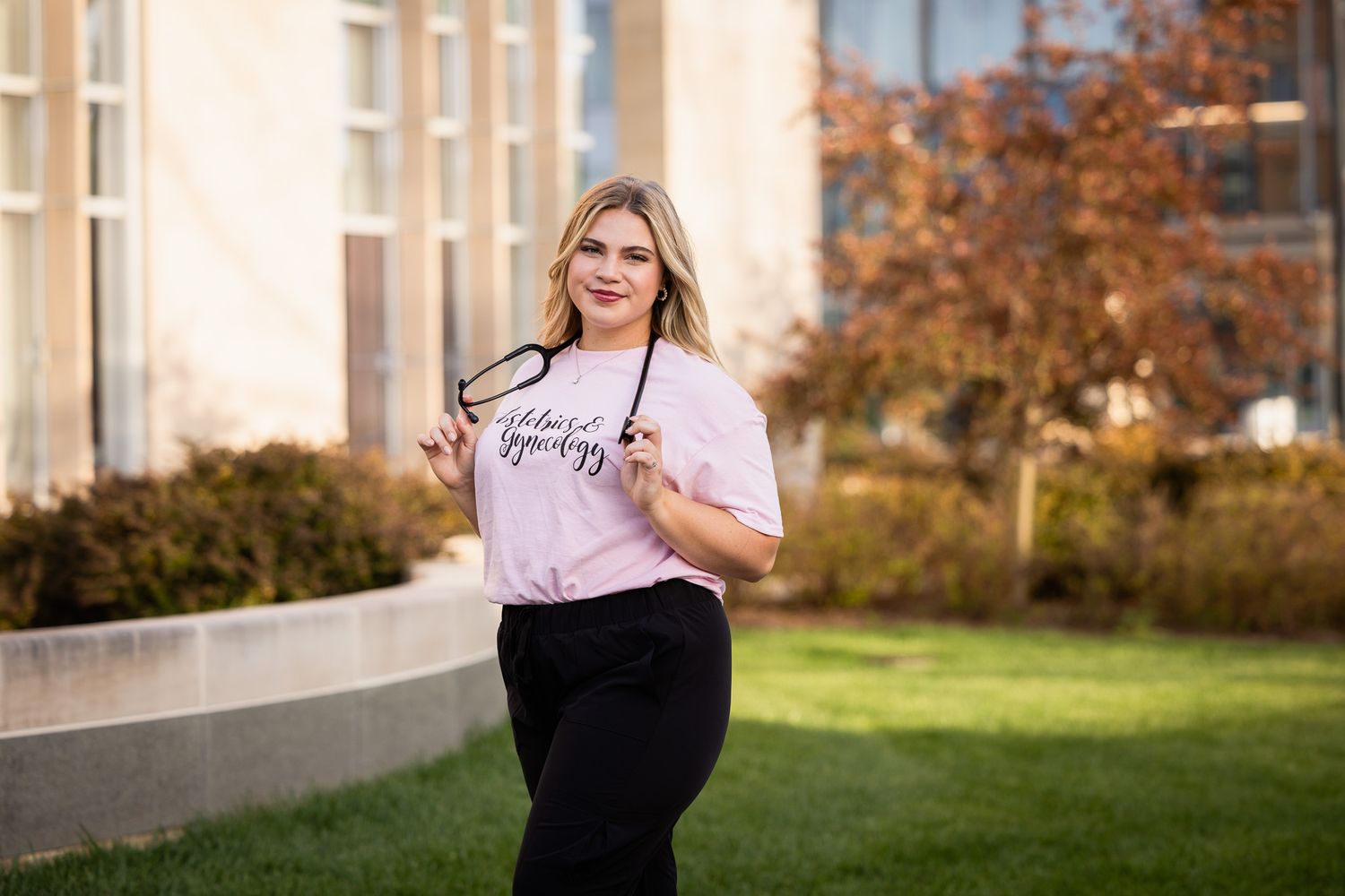 Student in casual attire posing for photos on campus during autumn.