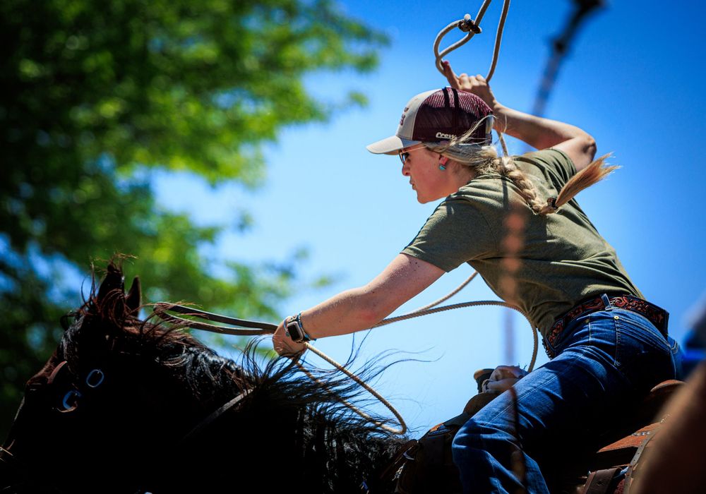 Action shot of rider mounting a horse during a western riding event.