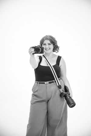 A person wearing loose overalls and a black top holds camera equipment in multiple poses.