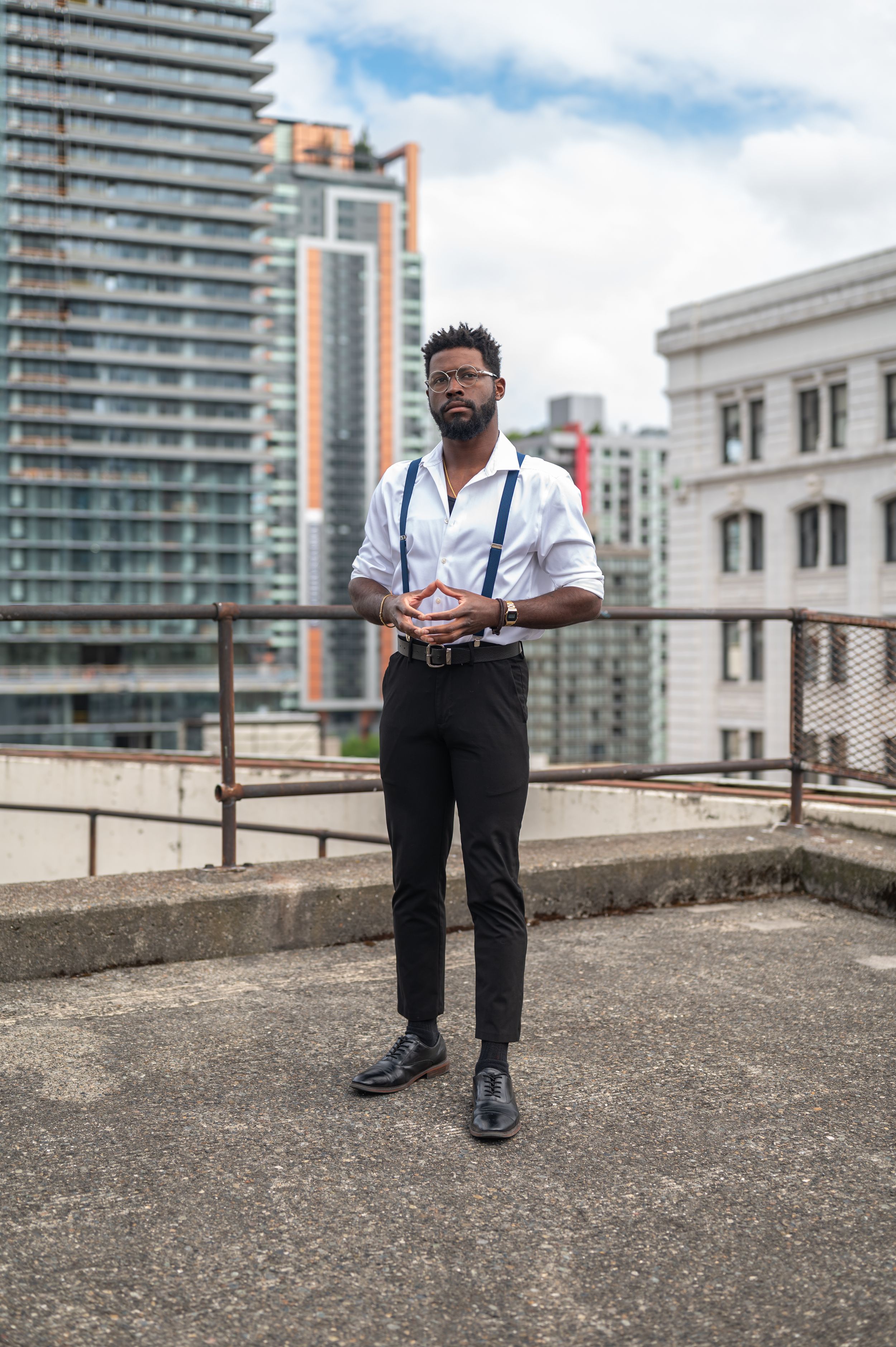 Classic business style with white shirt and suspenders on rooftop location.