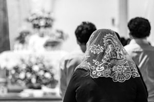 Elegant bride's veil photographed in black and white with delicate lace embroidery details along the edge.