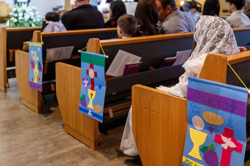 Colorful religious banners decorate wooden church pews during a worship service.