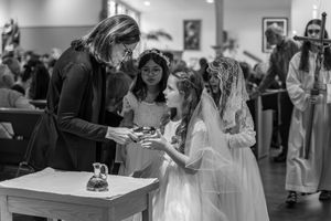 Black and white photo capturing joyful moments during a wedding celebration with guests mingling in a reception space.