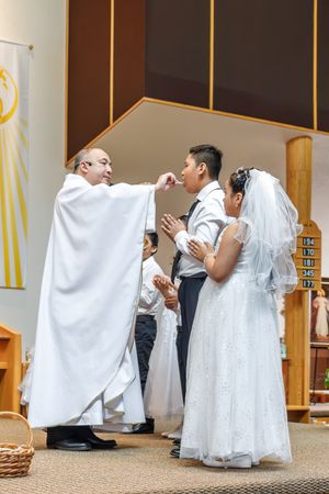 A collection of First Holy Communion photographs showing people in white garments kneeling in church.