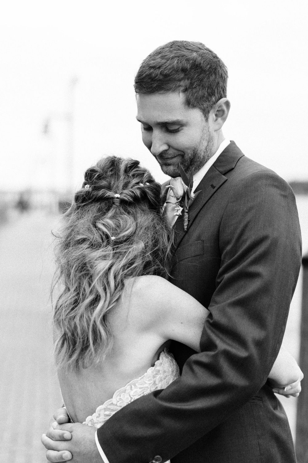 A romantic black and white embracing moment captured during a wedding celebration.