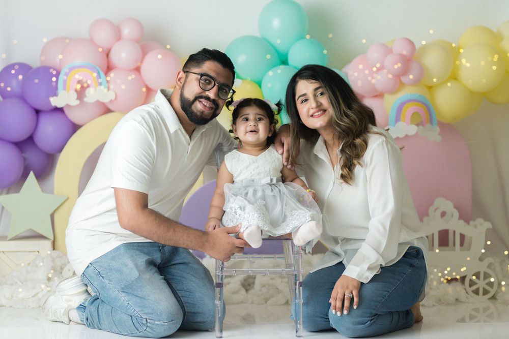 Colorful balloon backdrop with pastel rainbow colors behind family photo session.