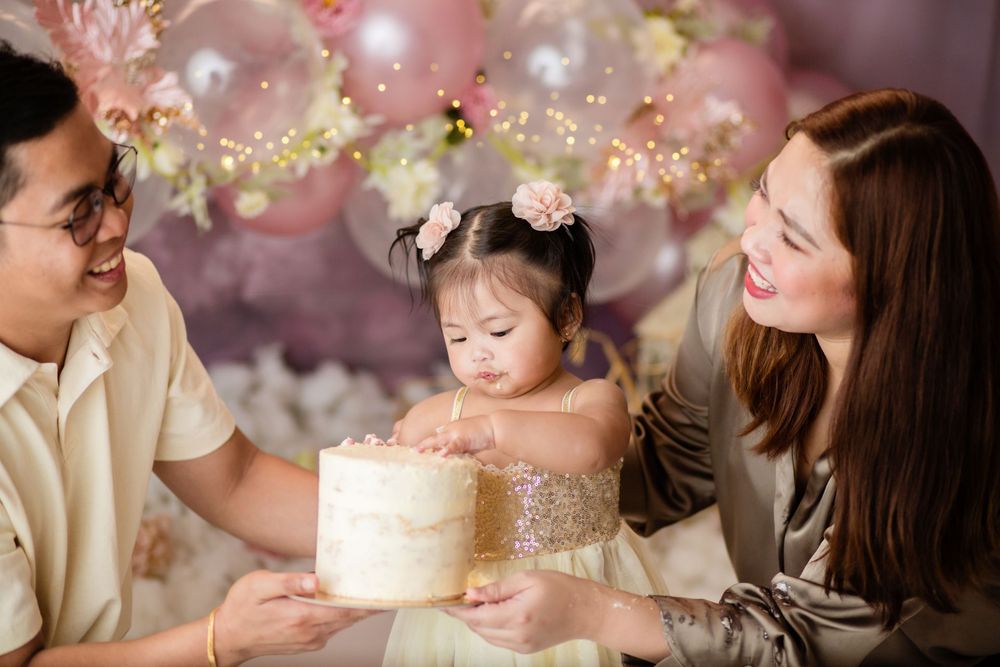 Birthday celebration setup with cake and pink balloon decorations.