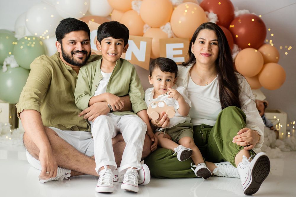 Family portrait setup with pastel balloon arch and neutral color scheme.