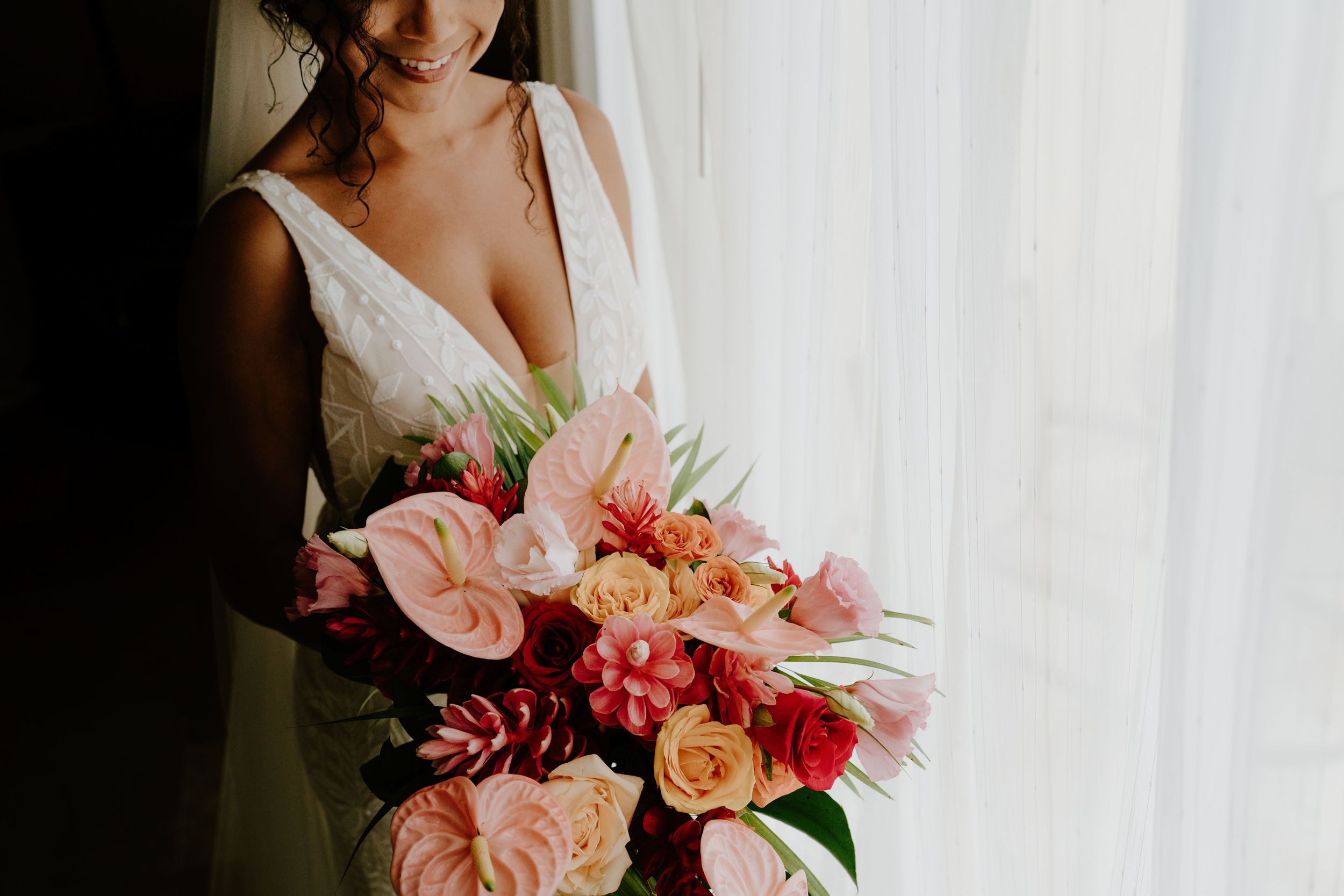 Romantic bridal bouquet featuring pink and coral roses with mixed flowers.