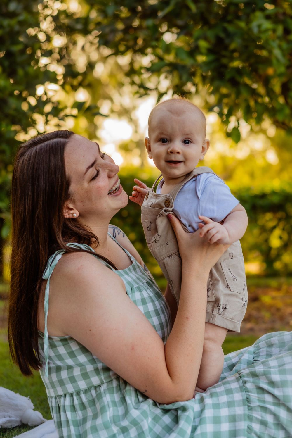 Joyful outdoor family portrait in garden with golden sunset lighting.