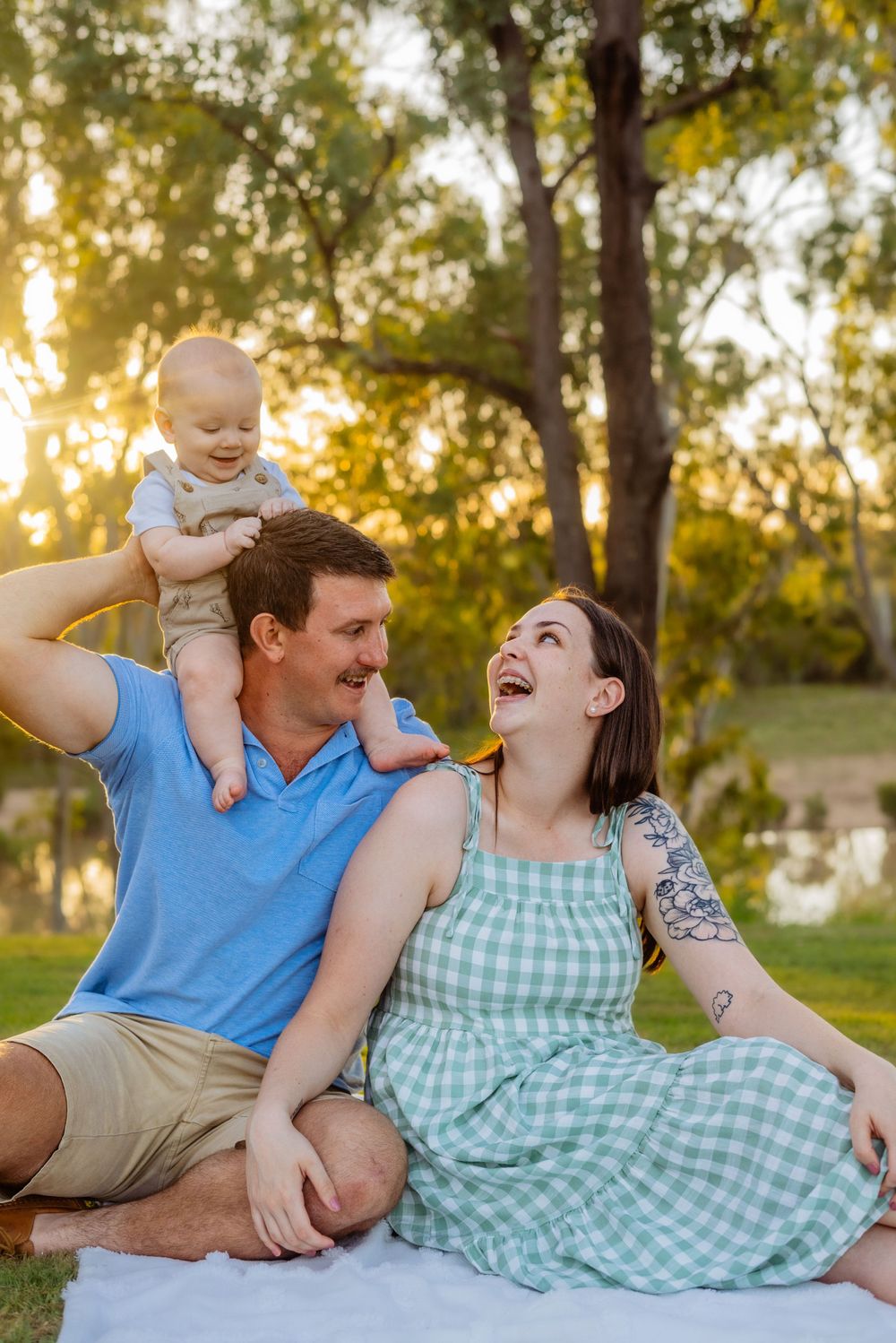 A joyful family moment captured on a picnic blanket during golden hour.