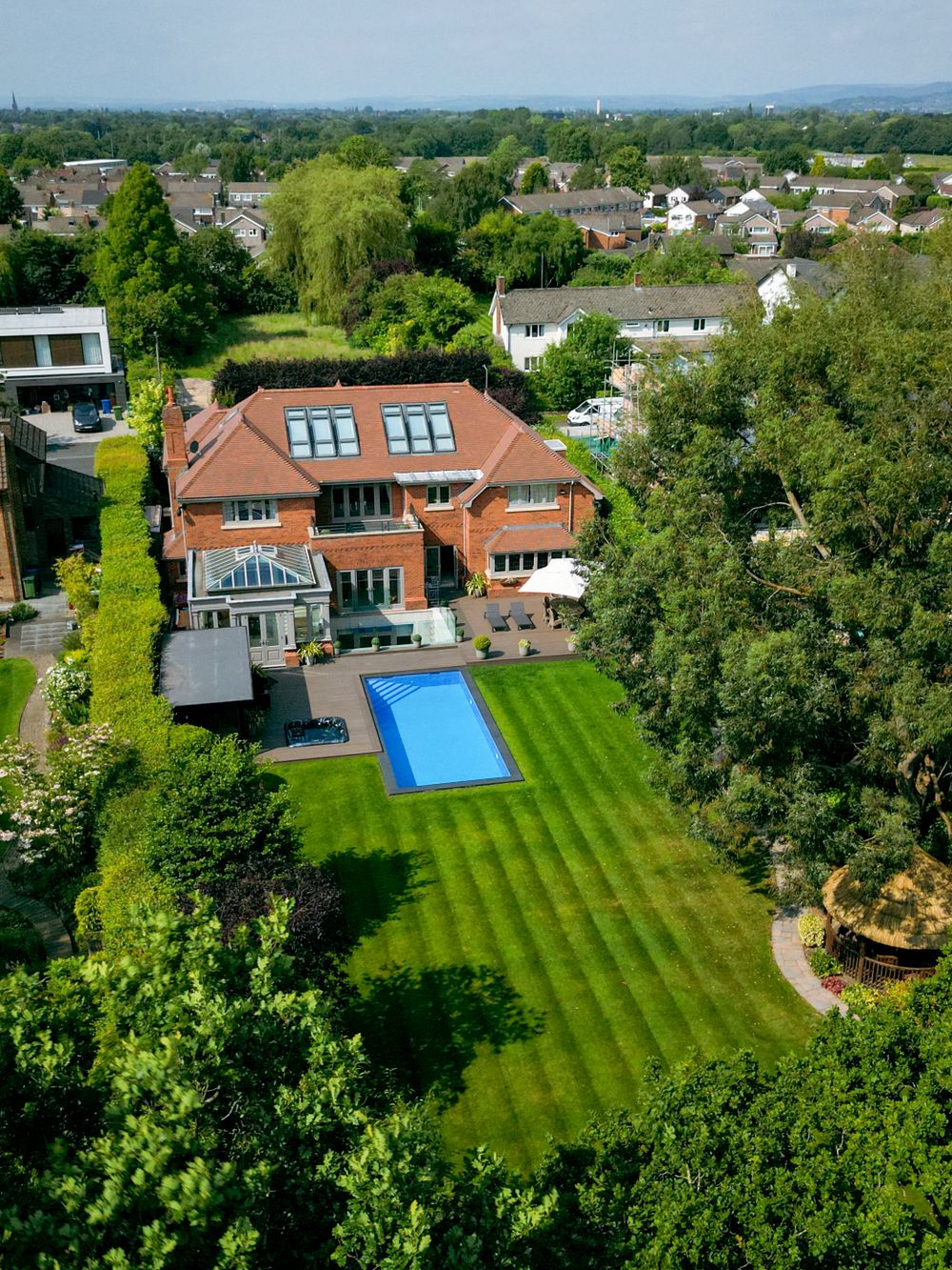 Aerial view of a large residential property with swimming pool and perfectly maintained lawn.