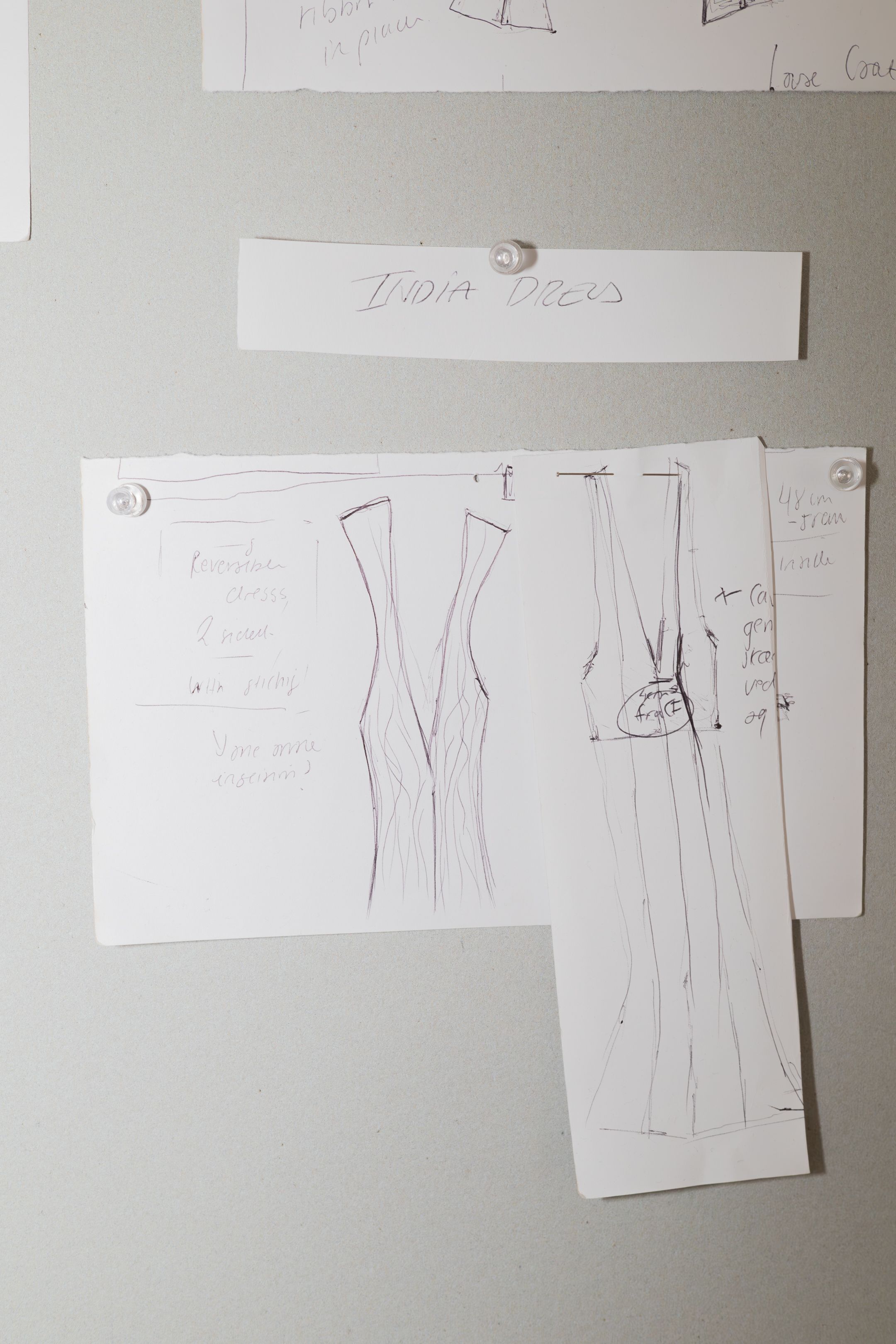 Simple sketch drawings of dress designs on white paper.