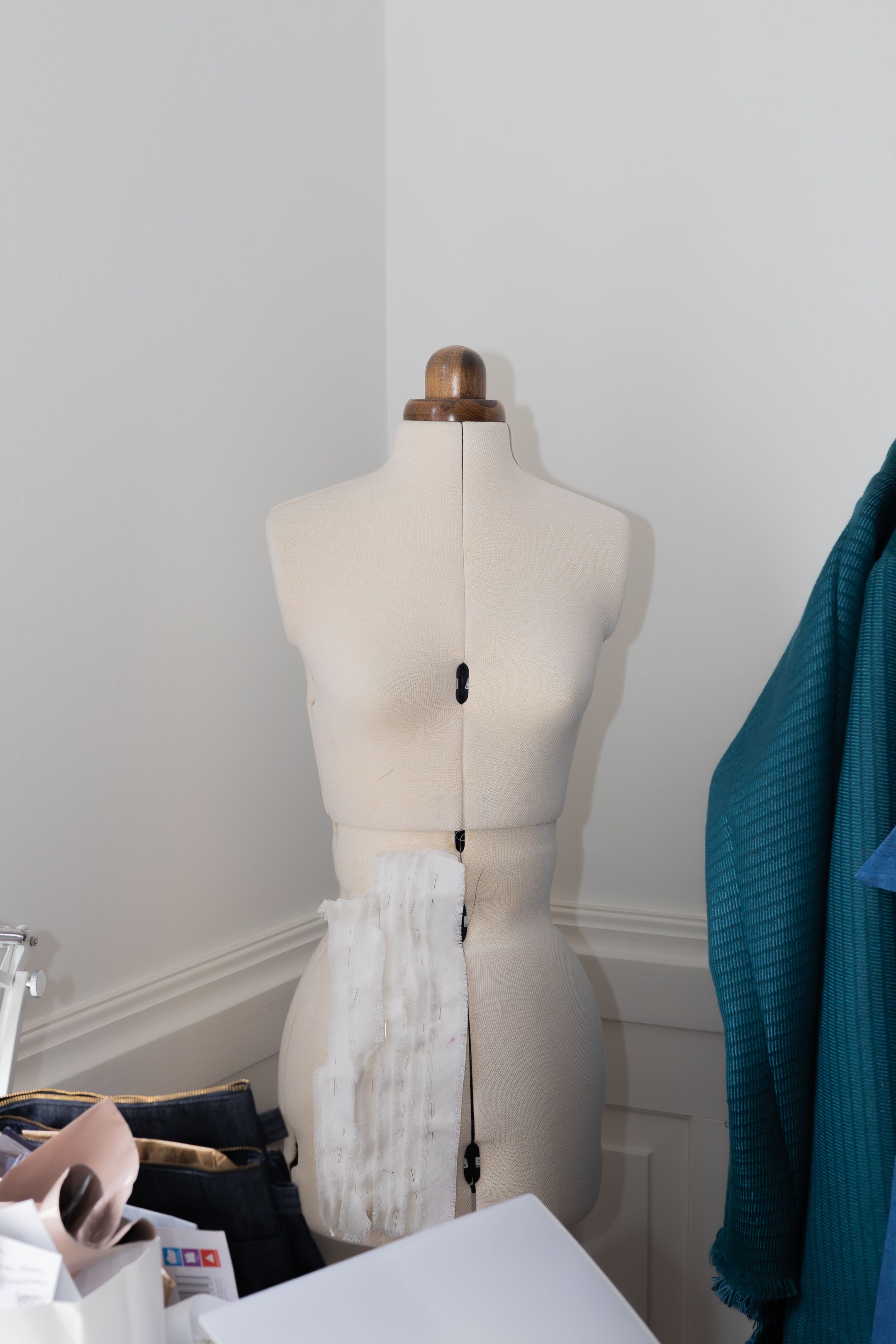 White dressmaker's mannequin form against a light wall background.