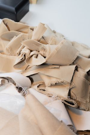 Close-up of beige fabric pieces with raw edges and frayed details.