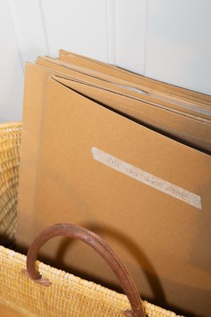 Manila folders organized in a woven basket with leather handle.