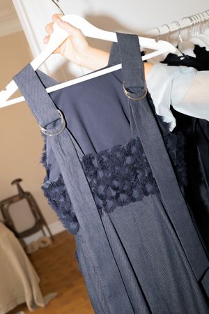 Elegant navy blue dress with textured pattern details displayed on white hanger.