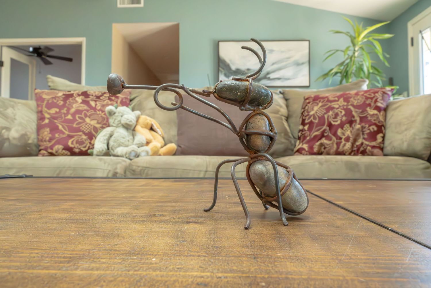 An ant playing trumpet is created out of thin twists of metal and rocks. Image demonstrates how f/16 aperture keeps background in focus.