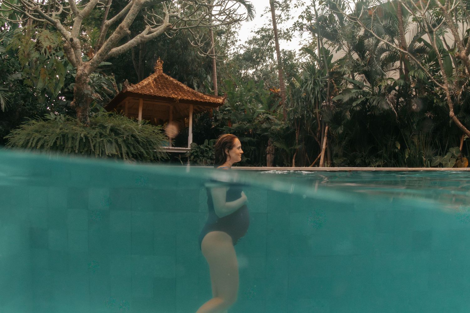 Split-view photograph of a swimming pool with a traditional Balinese gazebo surrounded by tropical forest.
