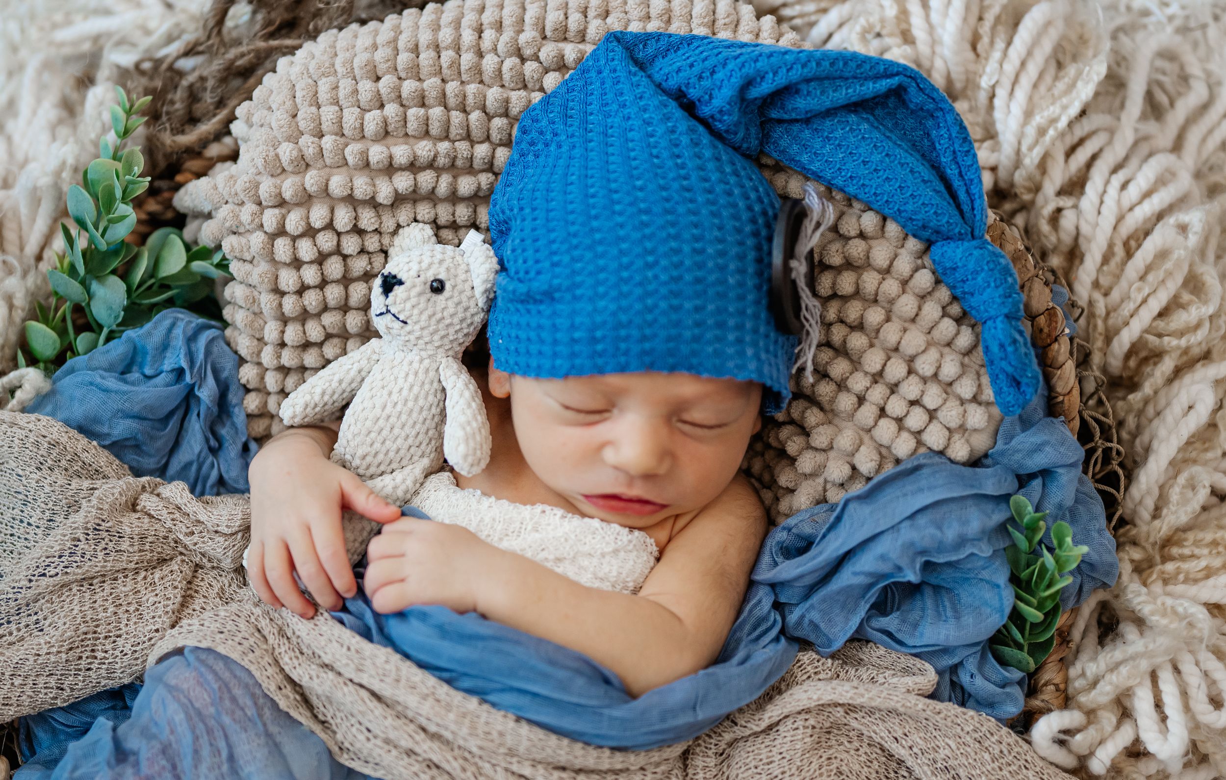 sweet baby boy newborn session tiny teddy bear cuddled knit newborn outfit swaddled cream and blue creative set basket