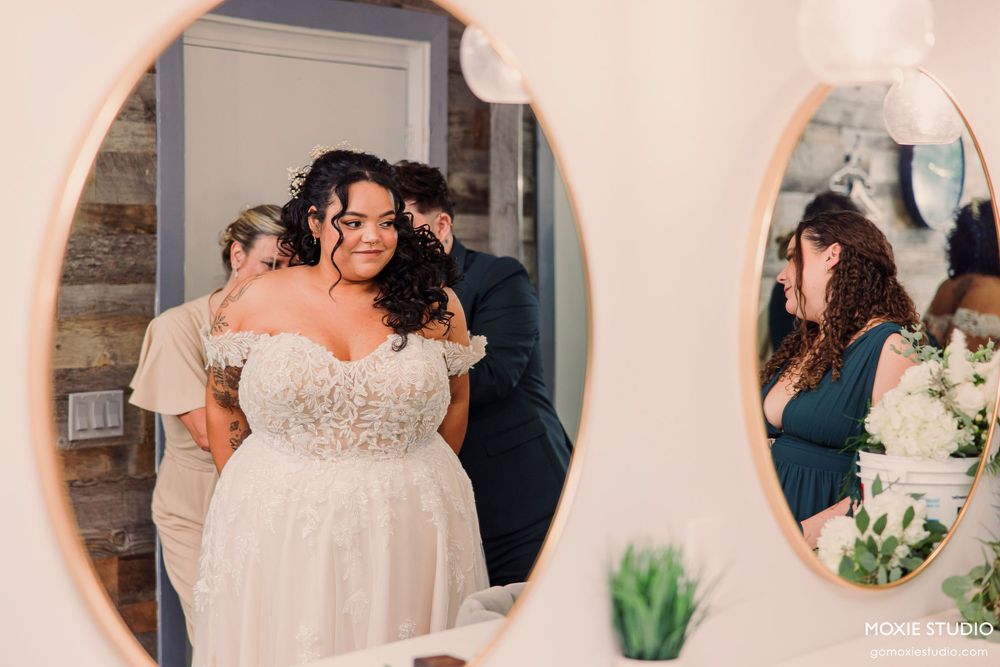 Wedding party members in navy blue and white dresses share joyful moments during reception celebrations.