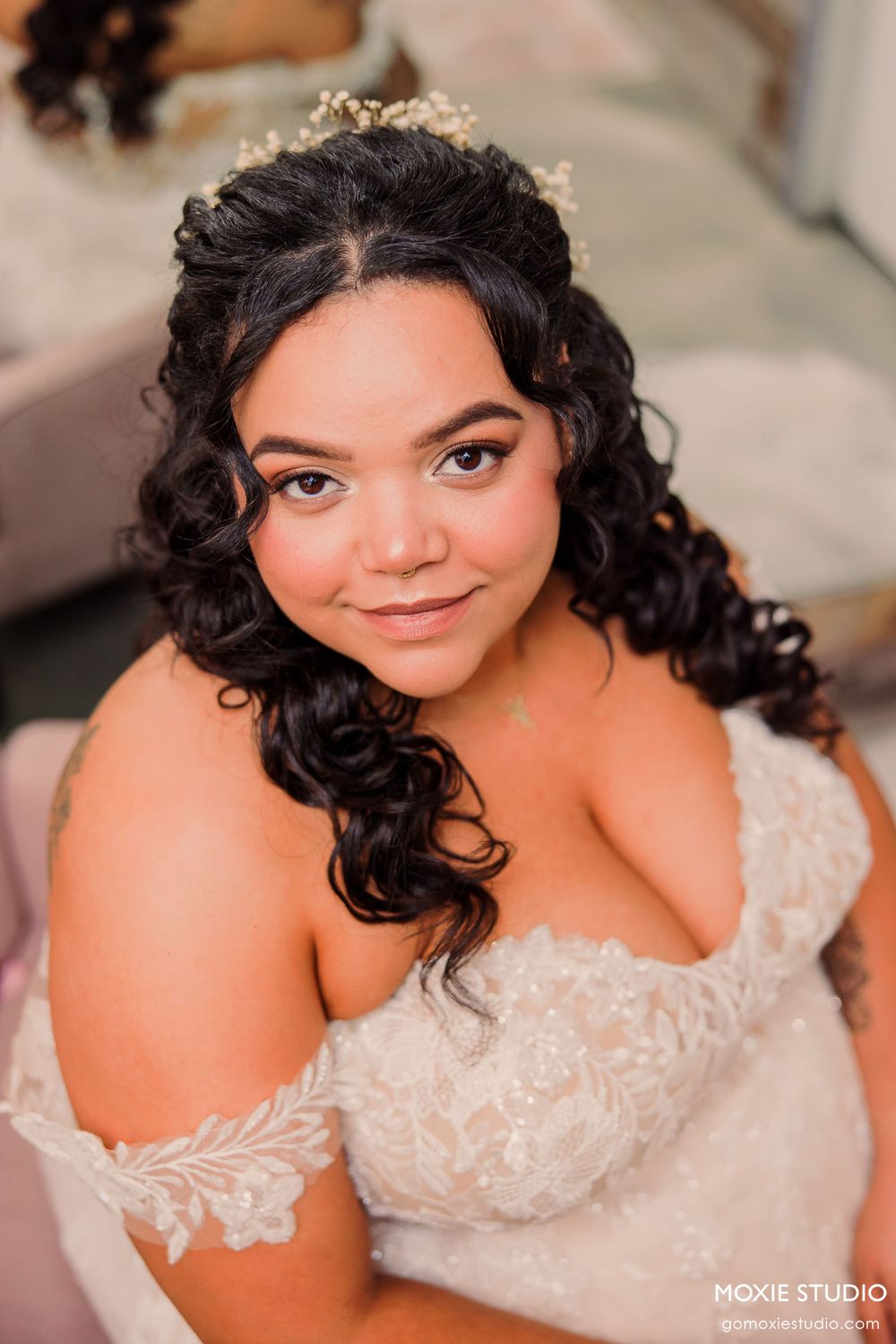 Close-up shots of a bride wearing an off-shoulder lace wedding gown with curly dark hair.