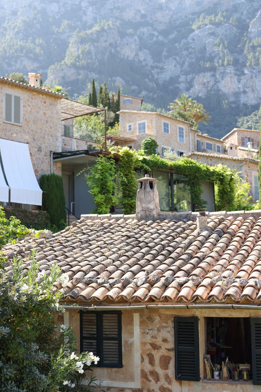 Traditional Mediterranean villa with terracotta roof tiles nestled in mountain landscape.