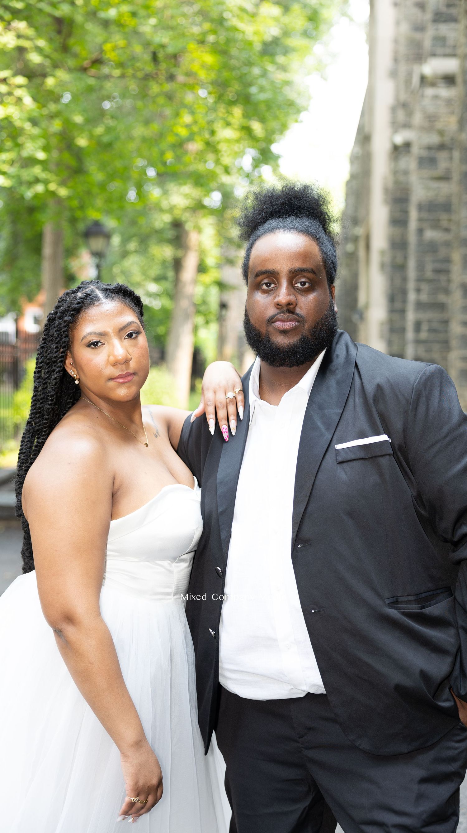 Formal portrait session in a tree-lined pathway.
