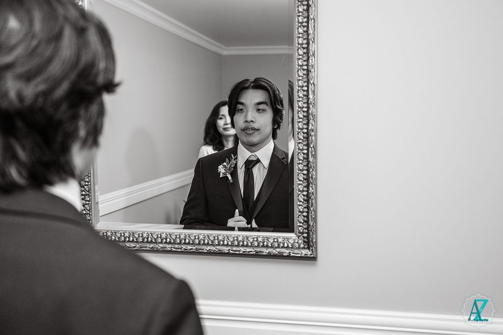 A reflection in an ornate mirror shows formal attire preparations.